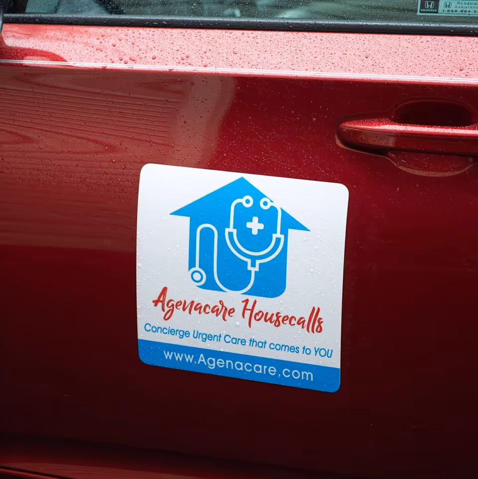 Close-up of a red car door featuring a blue Agenacare Housecalls sticker.