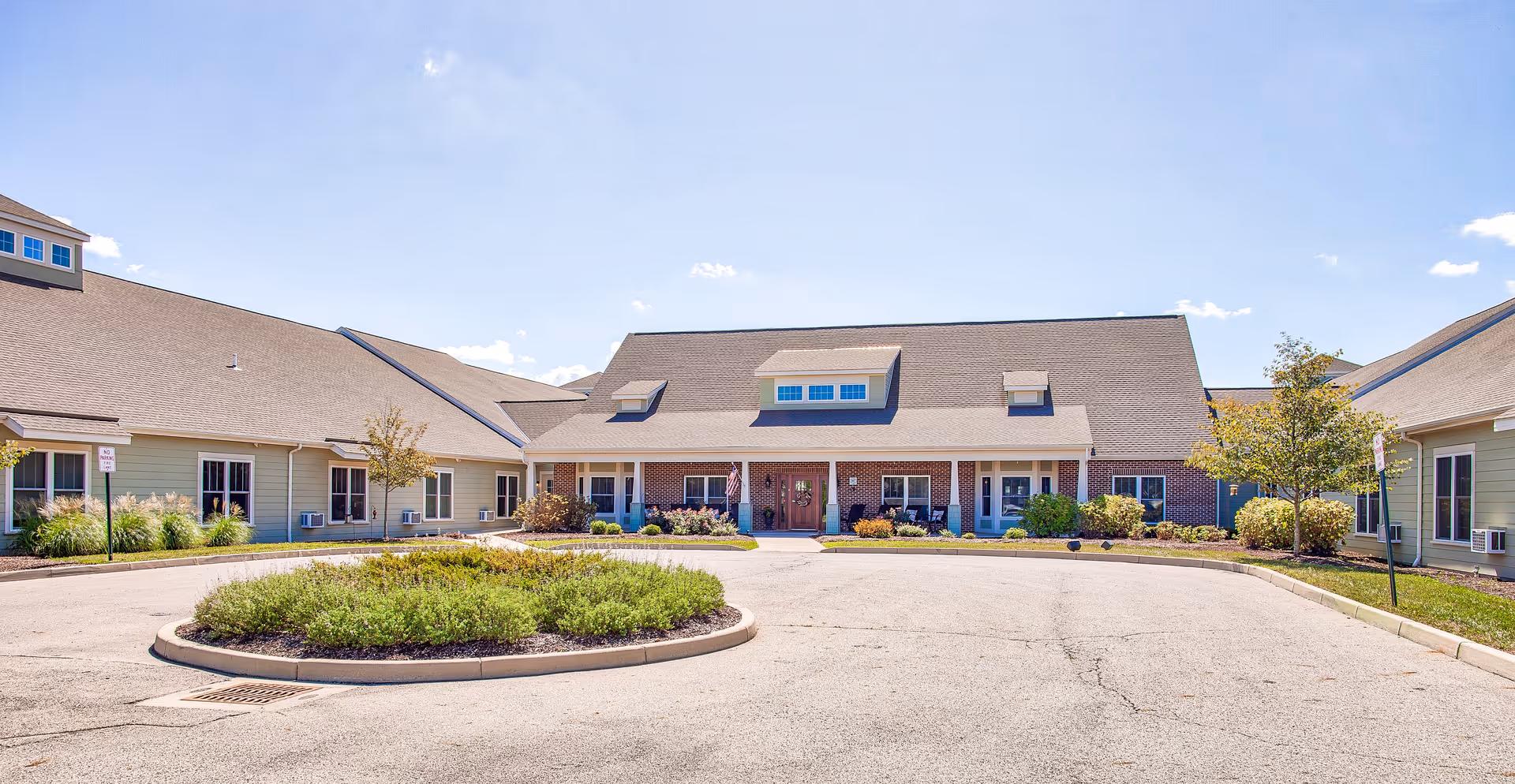 Wide view of the Atlantic Shore Retirement Residence exterior with a circular driveway and landscaping.