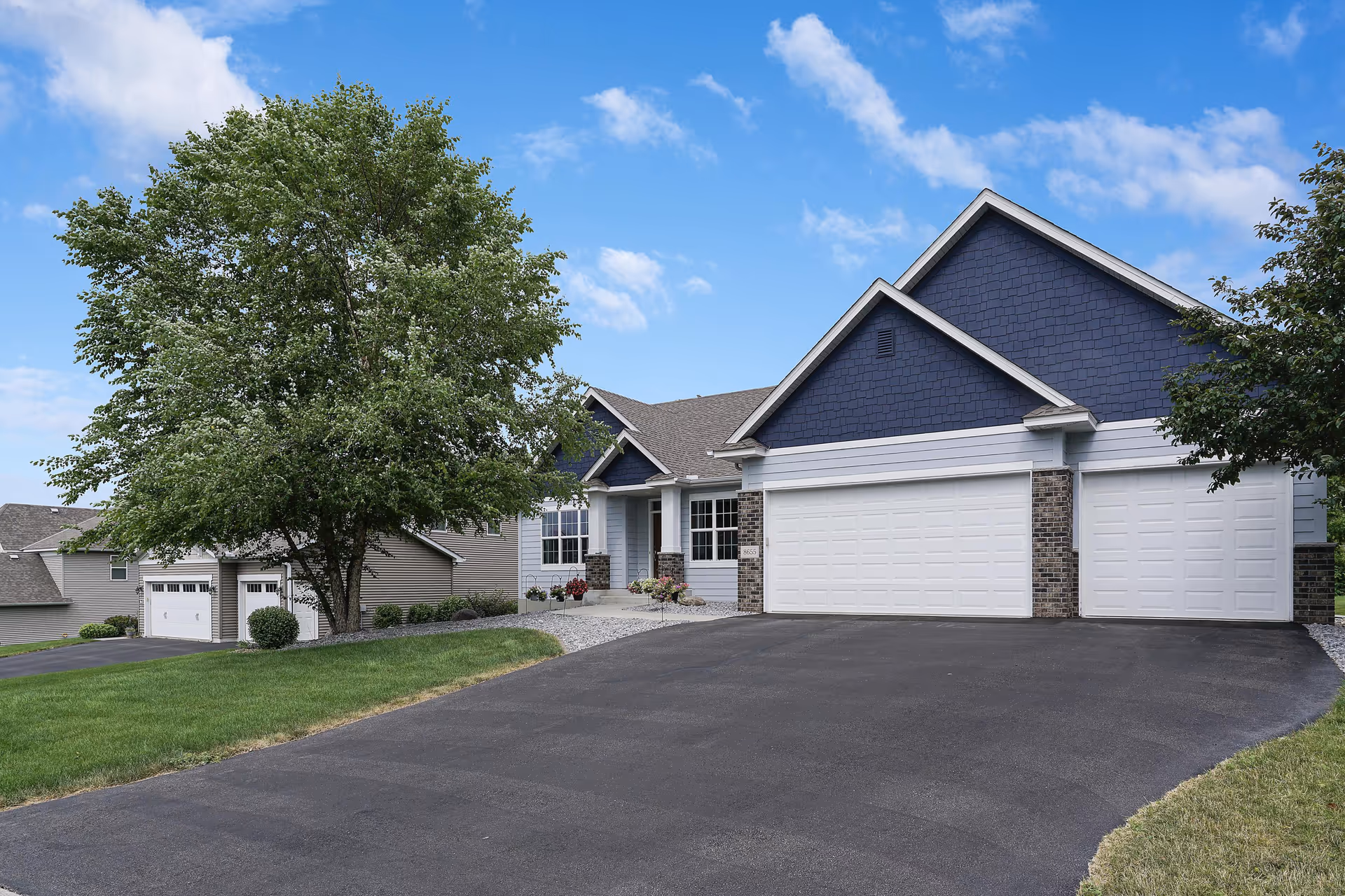 Front exterior of a modern assisted living facility with a three-bay garage.
