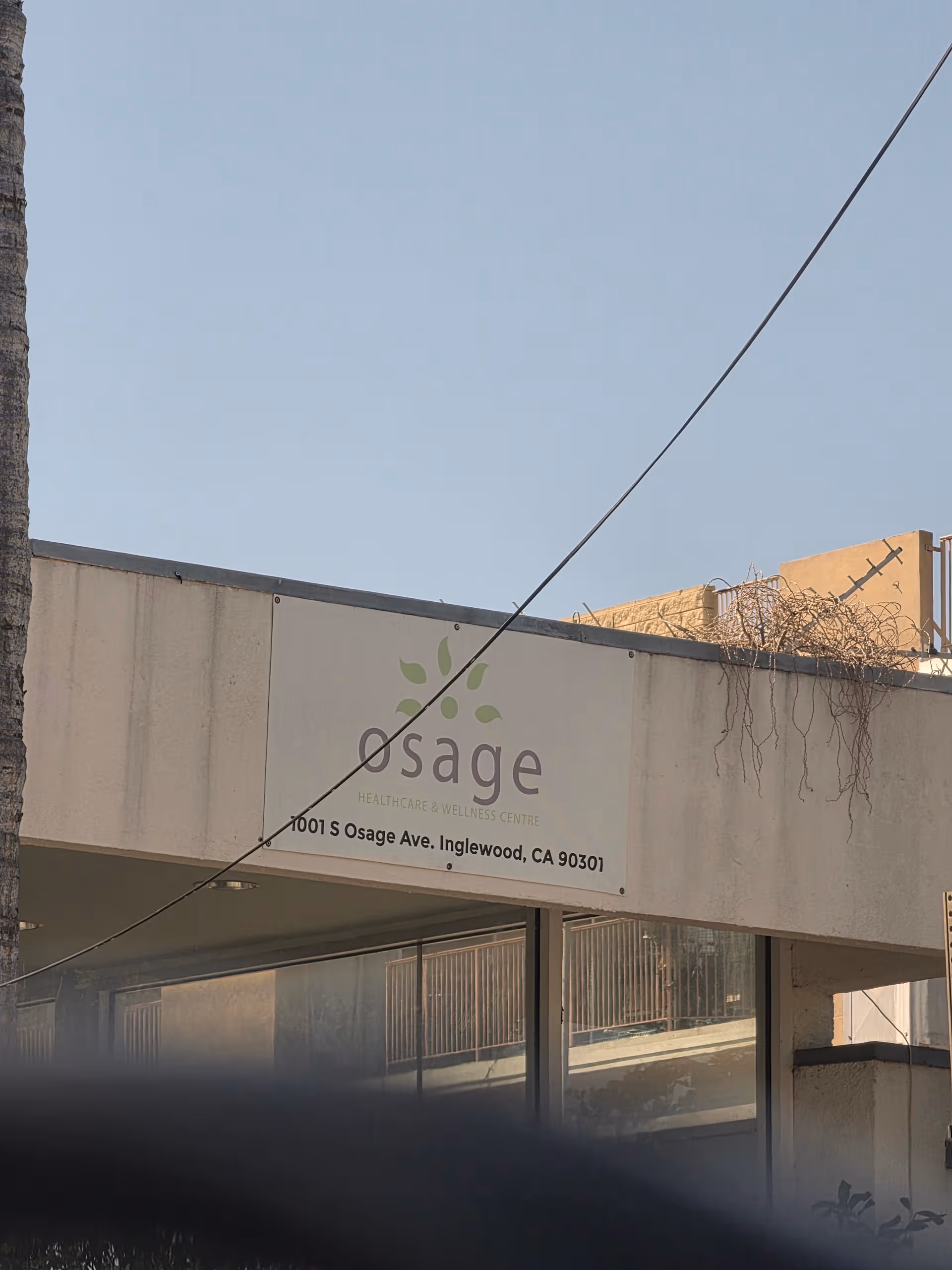 Beige building front with Osage Healthcare & Wellness Centre sign under clear blue sky