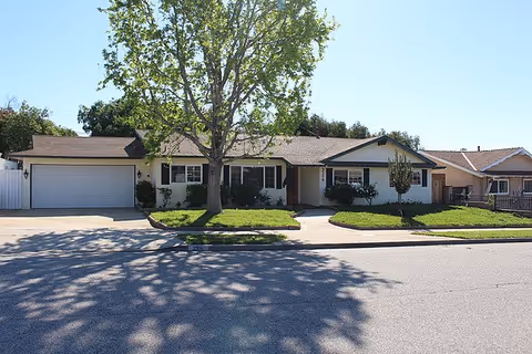 Front exterior view of a Regal Care senior living home with manicured lawn and driveway.