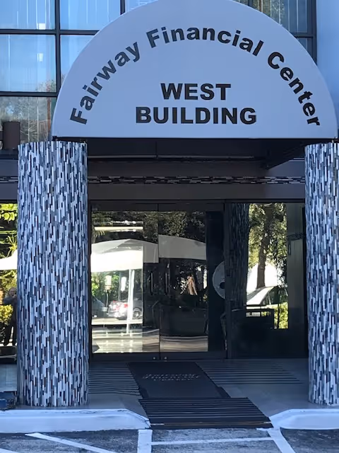 Front entrance of a building with a curved sign reading Fairway Financial Center West Building