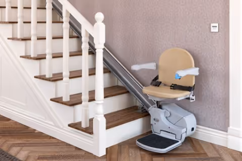Interior staircase with a wall-mounted stair lift and beige seat.