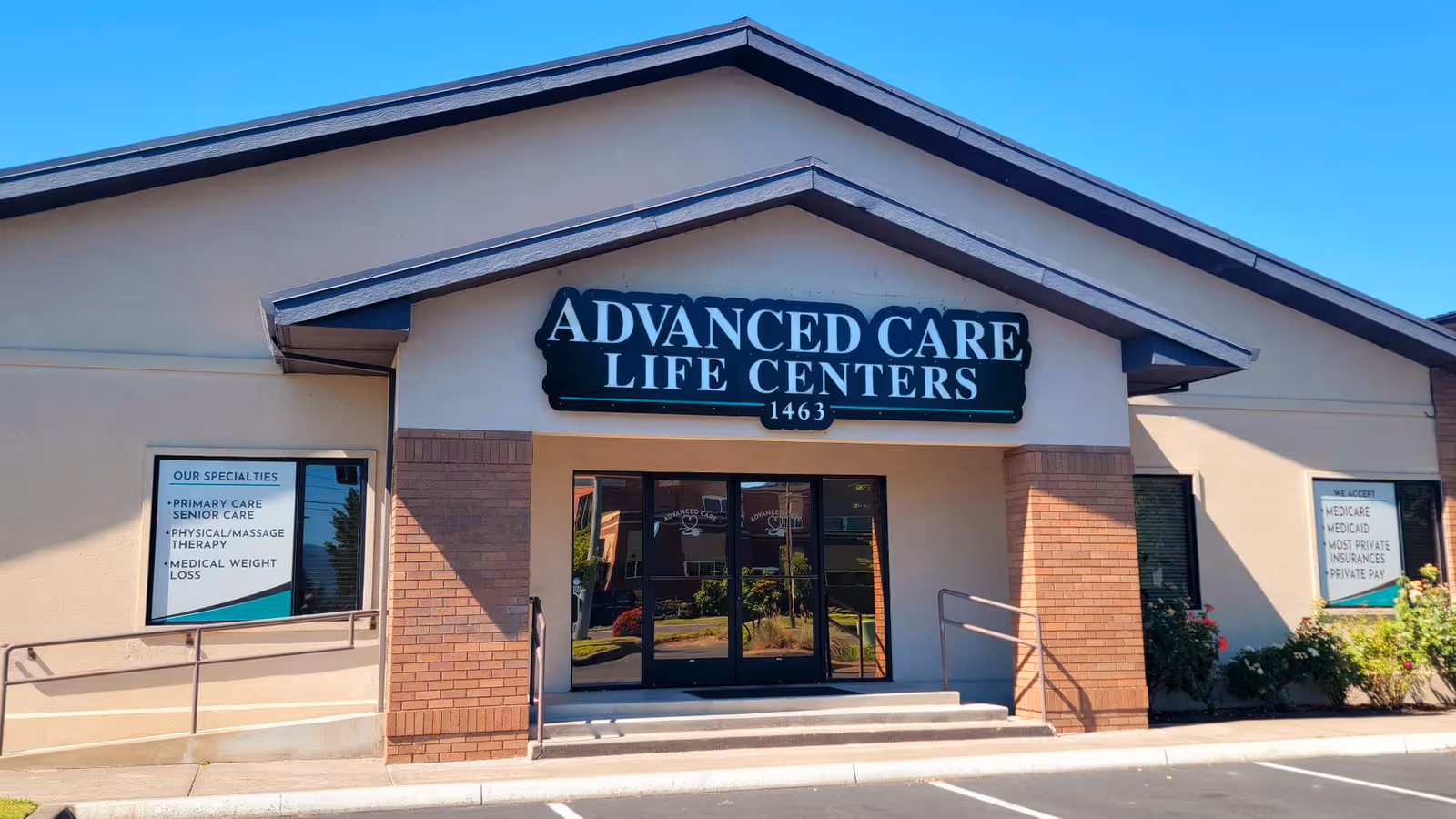 Front exterior of Advanced Care Life Centers with glass doors and brick pillars.