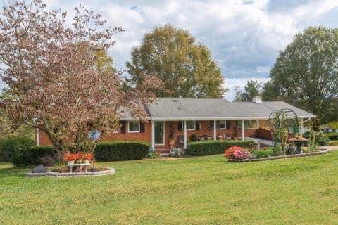 Single-story brick senior living facility with a manicured lawn and trees.