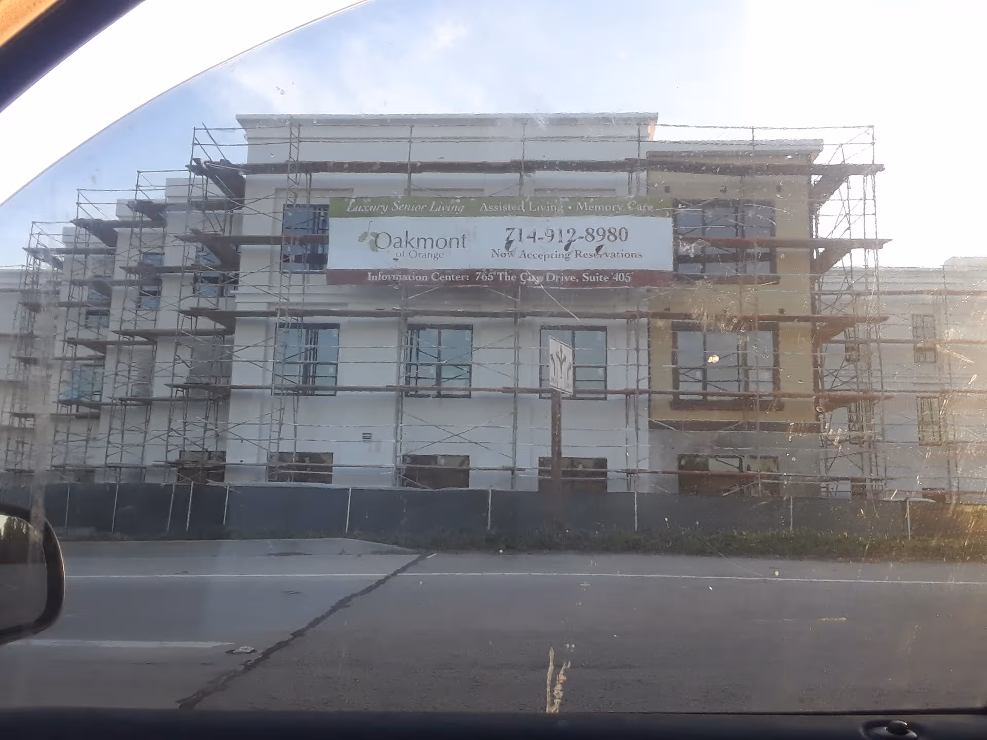 Scaffolding surrounds a multi-story Oakmont of Orange building under construction.