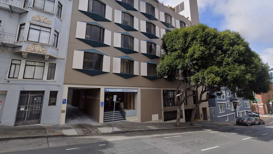 Exterior street view of City View Post Acute building with entrance and large tree.