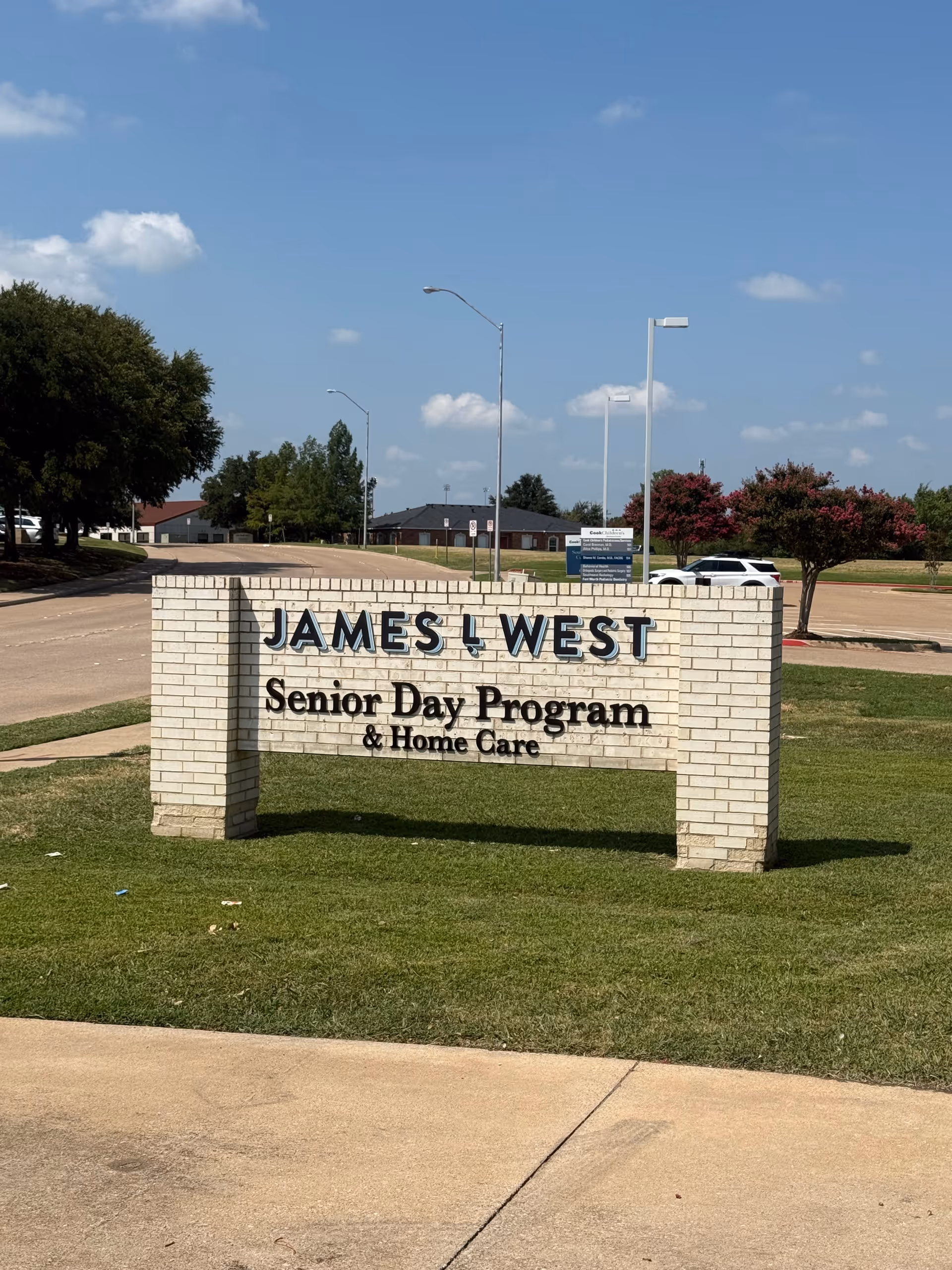 Brick sign with James L West Senior Day Program & Home Care in a grassy lot.