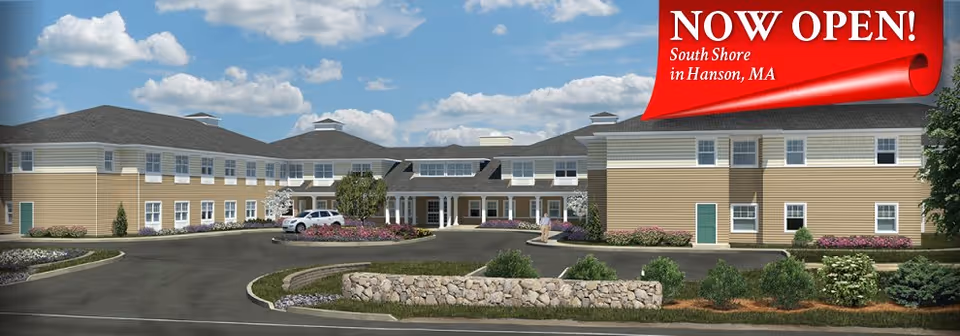 Exterior view of All American Assisted Living at Hanson with a Now Open banner.