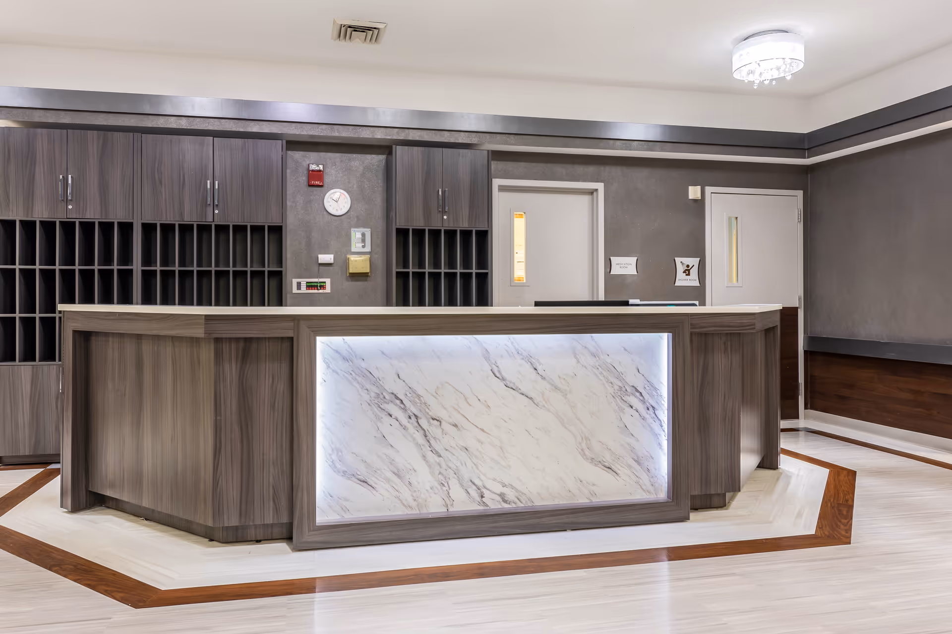 Modern reception desk with marble paneling in a senior living facility lobby.