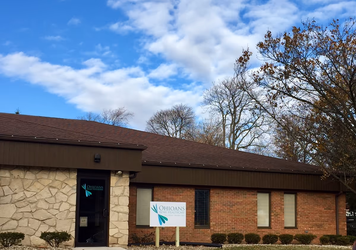 Single-story brick building with stone entry, blue sky, and an Ohioans Home Health & Hospice sign.