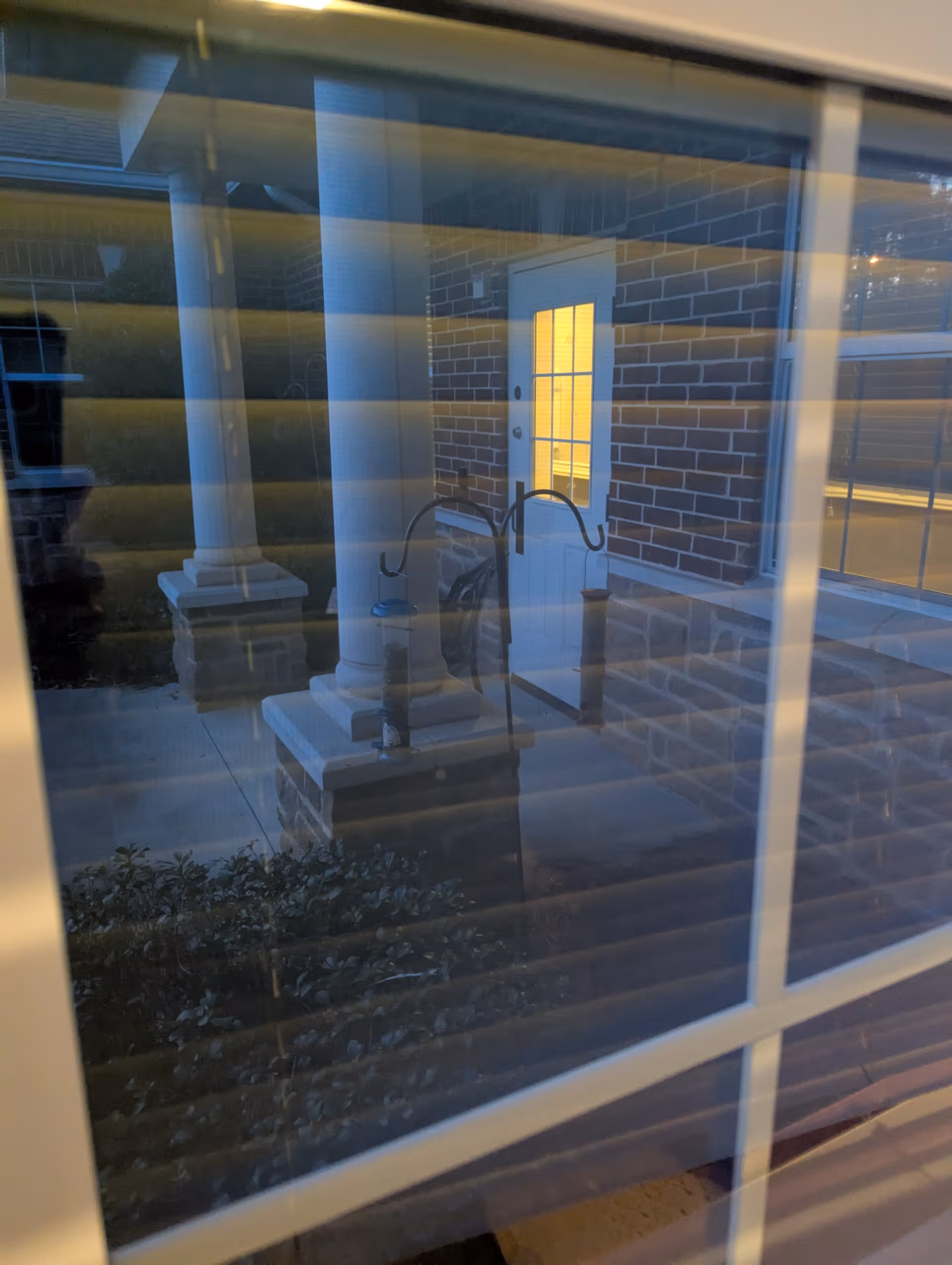 Brick exterior with porch columns and a glass door at the front entrance.