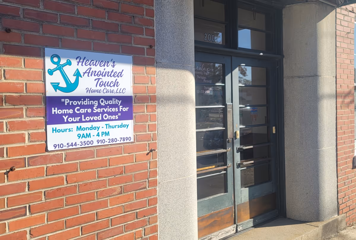 Exterior brick building with a sign for Heaven's Anointed Touch Home Care LLC and glass doors.