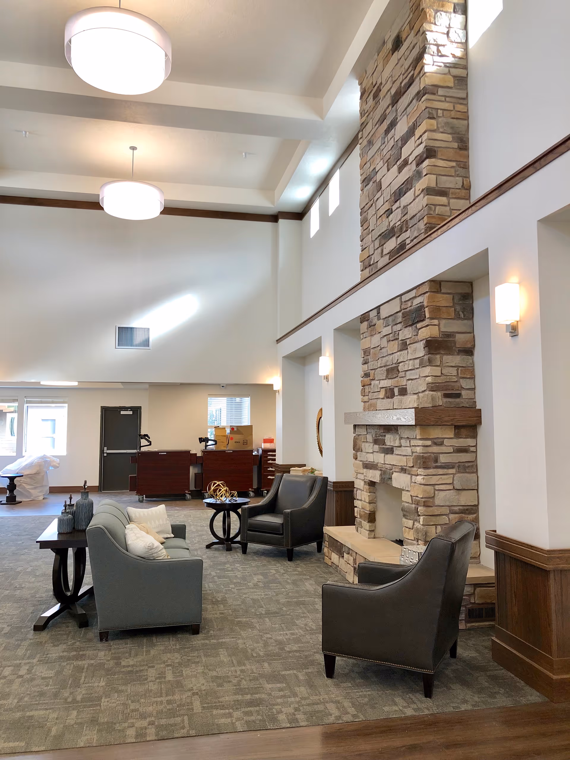 Meridian Meadows lobby with stone fireplace, contemporary seating, and a high vaulted ceiling.