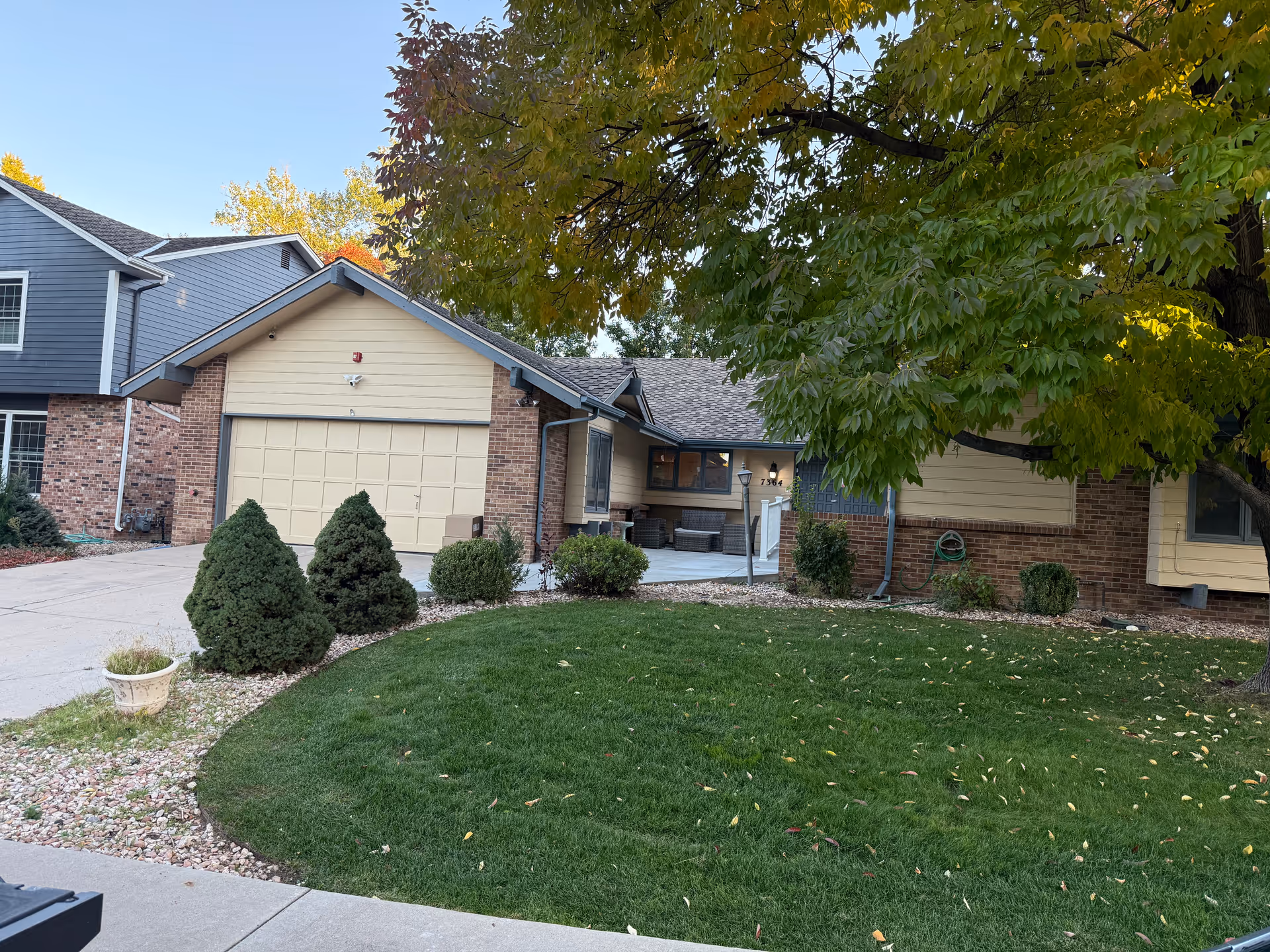 Single-story senior care facility exterior with driveway, garage, and well-kept front lawn.
