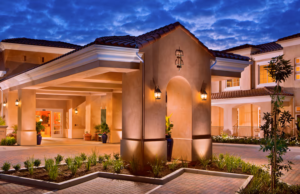 Evening exterior view of GlenBrook Health Center entrance with a covered driveway and landscaping.