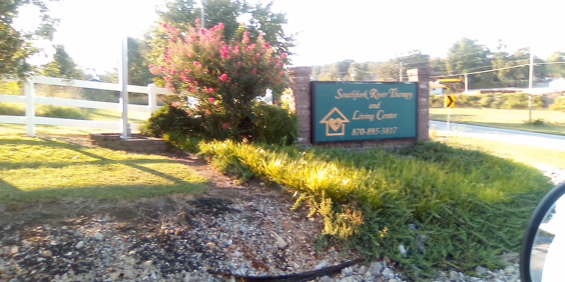 Green landscaped entrance with a teal sign for Southfork River Therapy and Living Center.