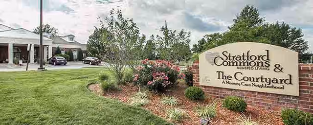 Exterior view of Stratford Commons Memory Care with landscaped entry sign.