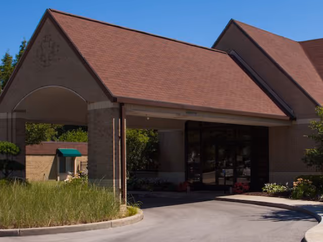 Exterior view of Medilodge at the Shore entrance with brick facade and canopy