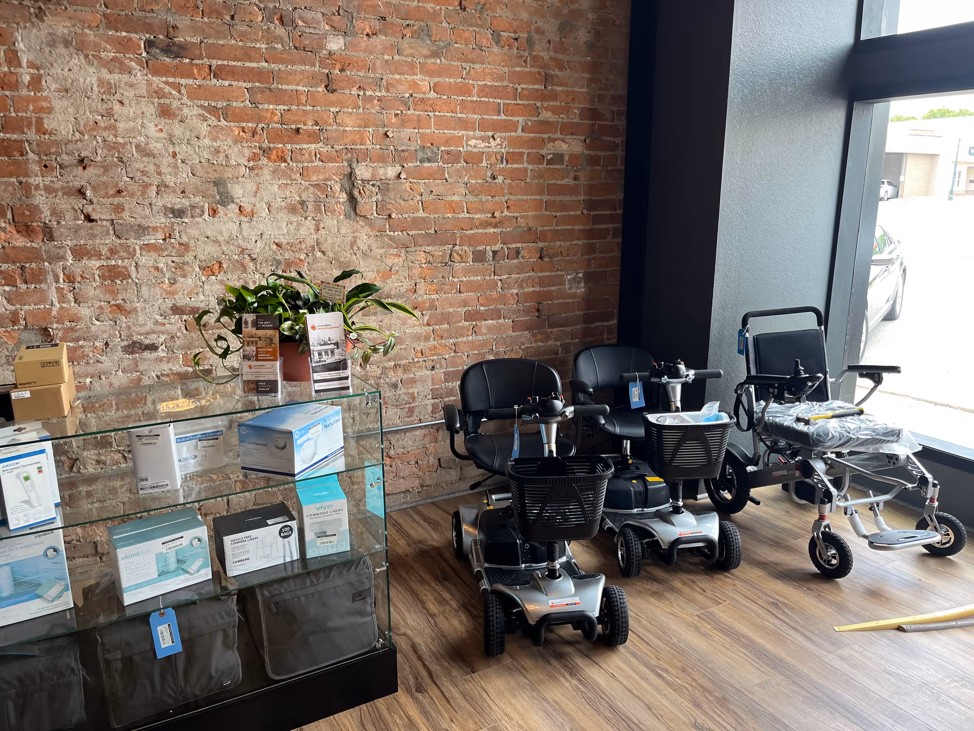Indoor showroom with brick wall, glass display case, and lined mobility scooters.