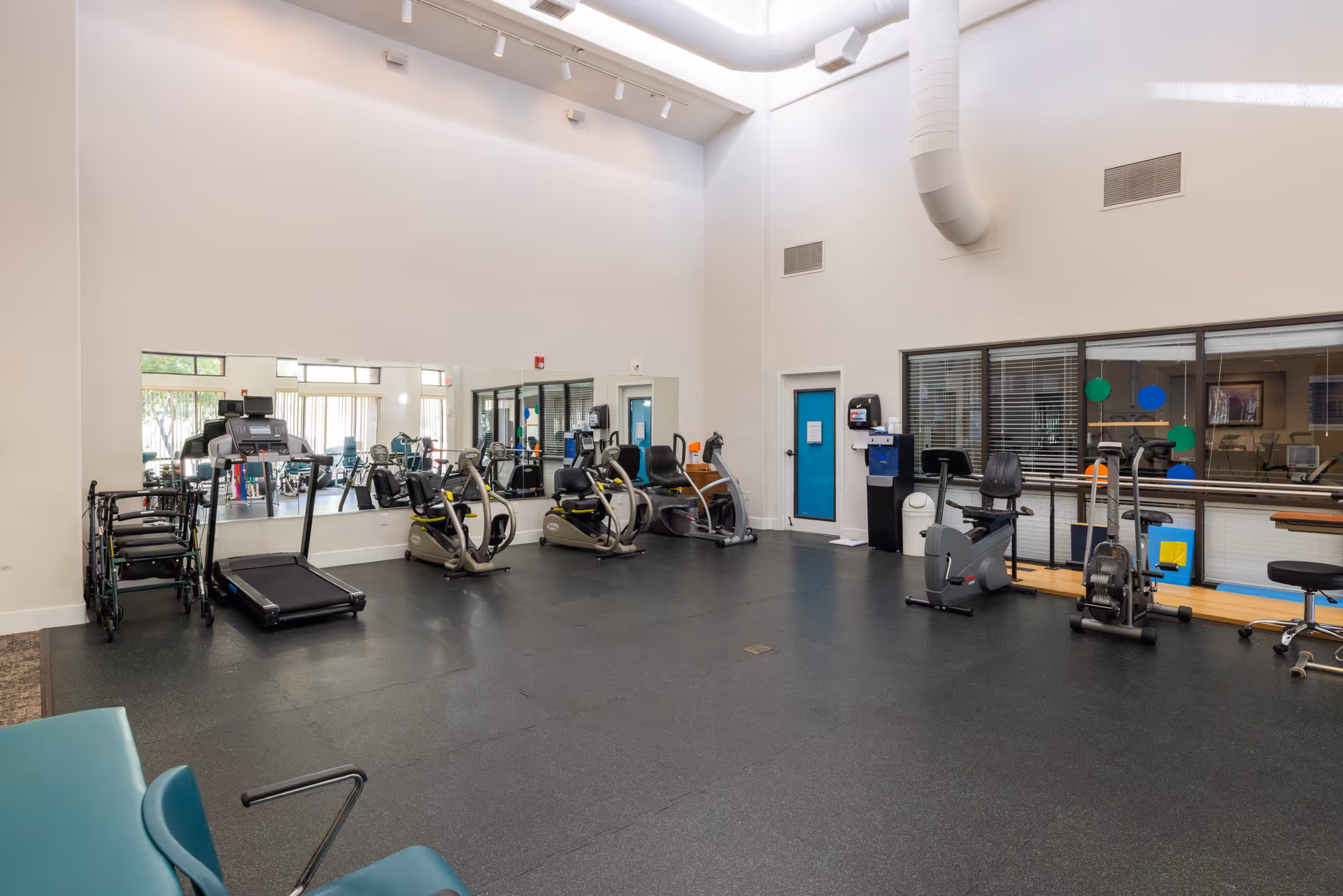 Bright senior fitness center with treadmills, bikes, and exercise equipment.