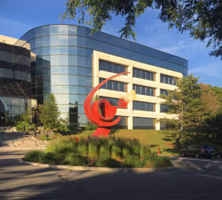 Modern Covenant Care building exterior with a red abstract sculpture and landscaped grounds.