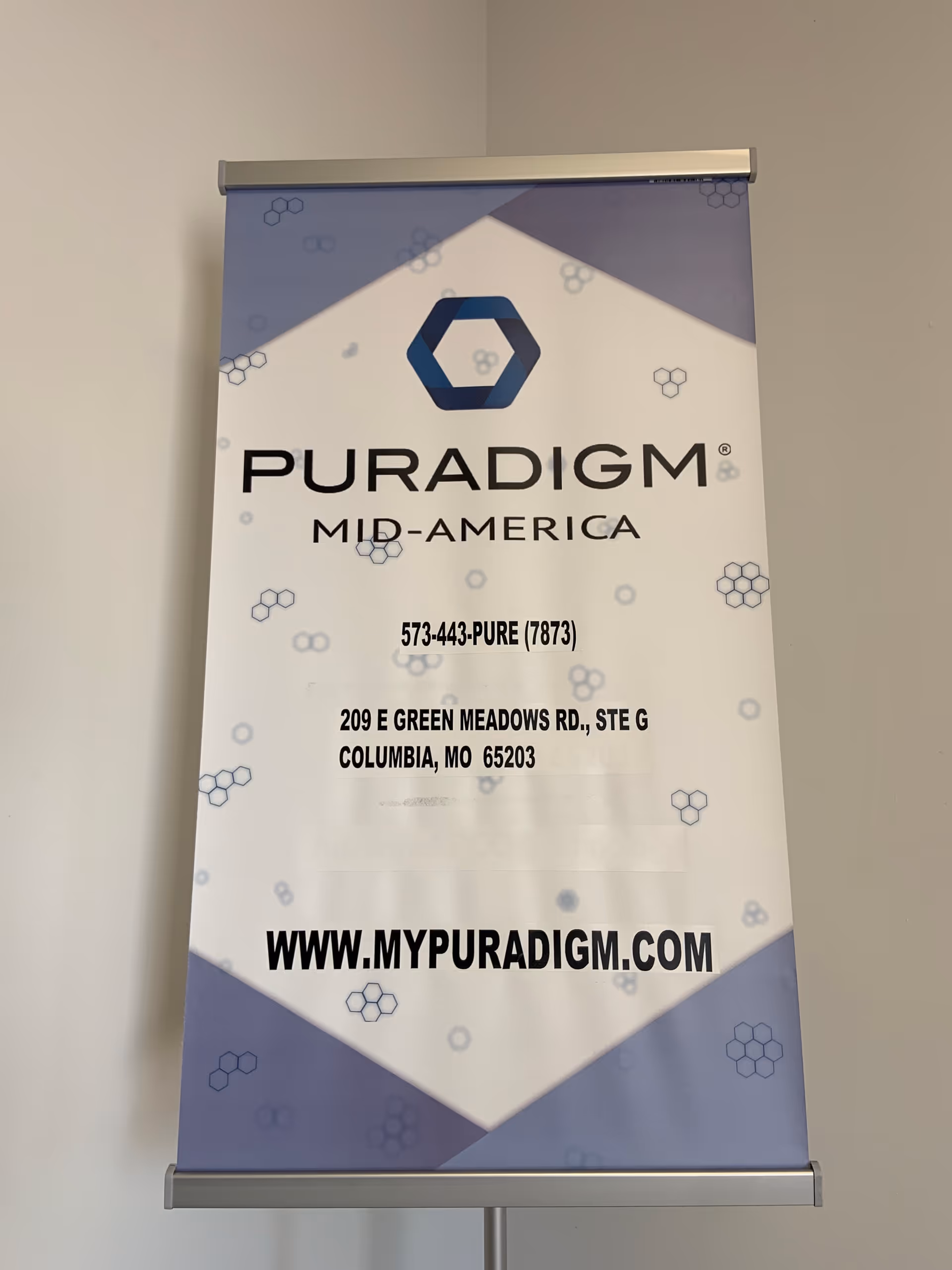 Vertical banner indoors displaying Puradigm Mid-America logo and contact details.