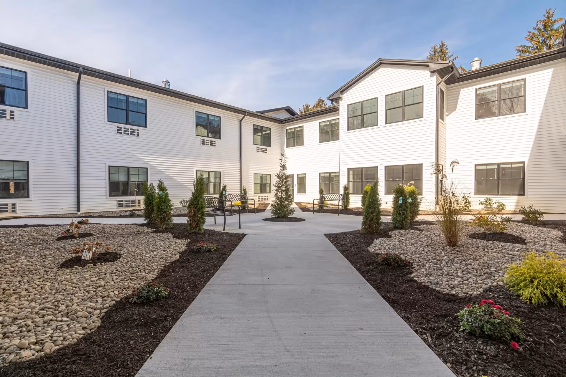 Atrium of Allentown exterior: white building surrounds a paved courtyard with benches.