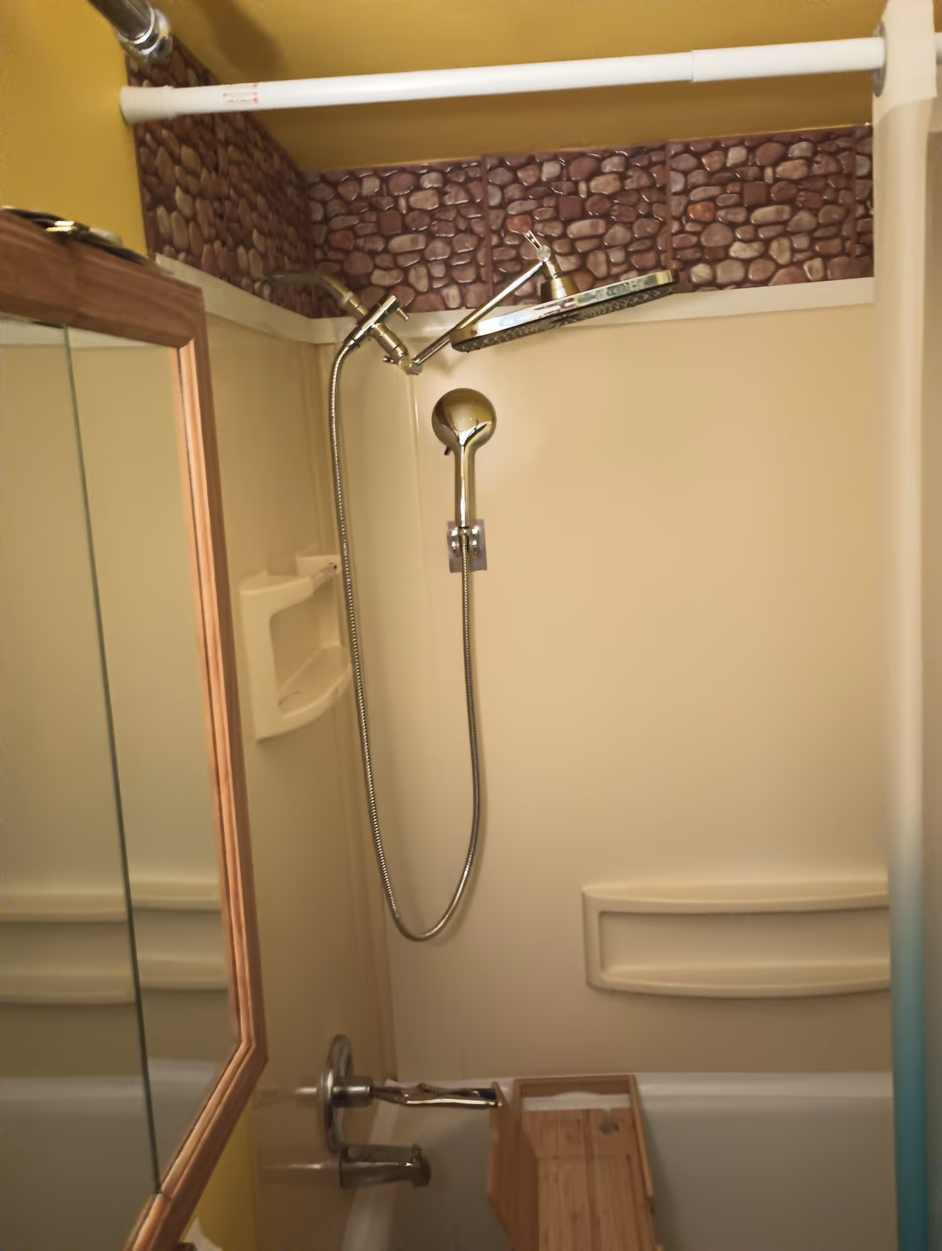 A compact bathroom with a handheld shower and built-in shelf.