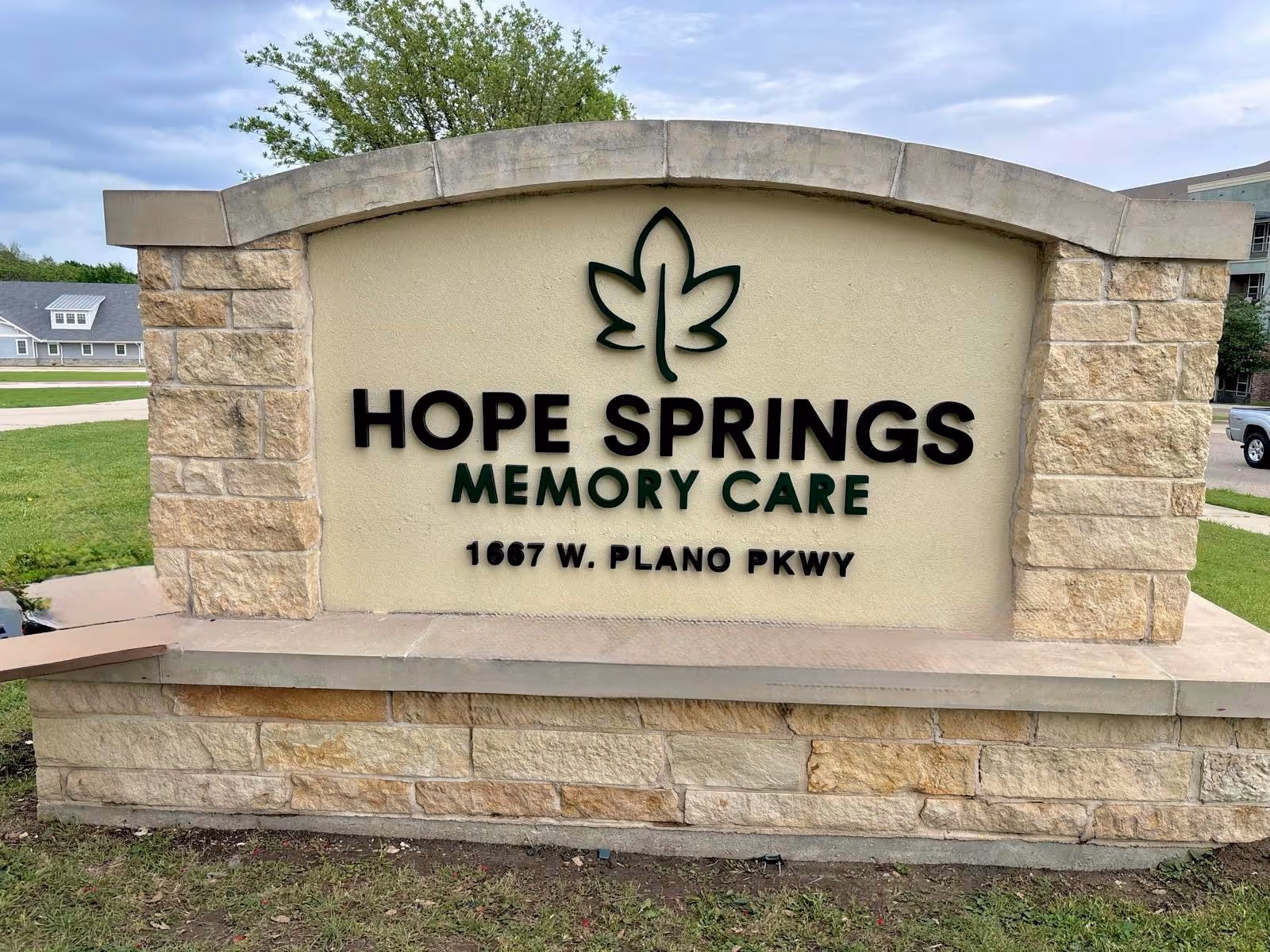 Stone sign reads Hope Springs Memory Care at the facility's front entrance.
