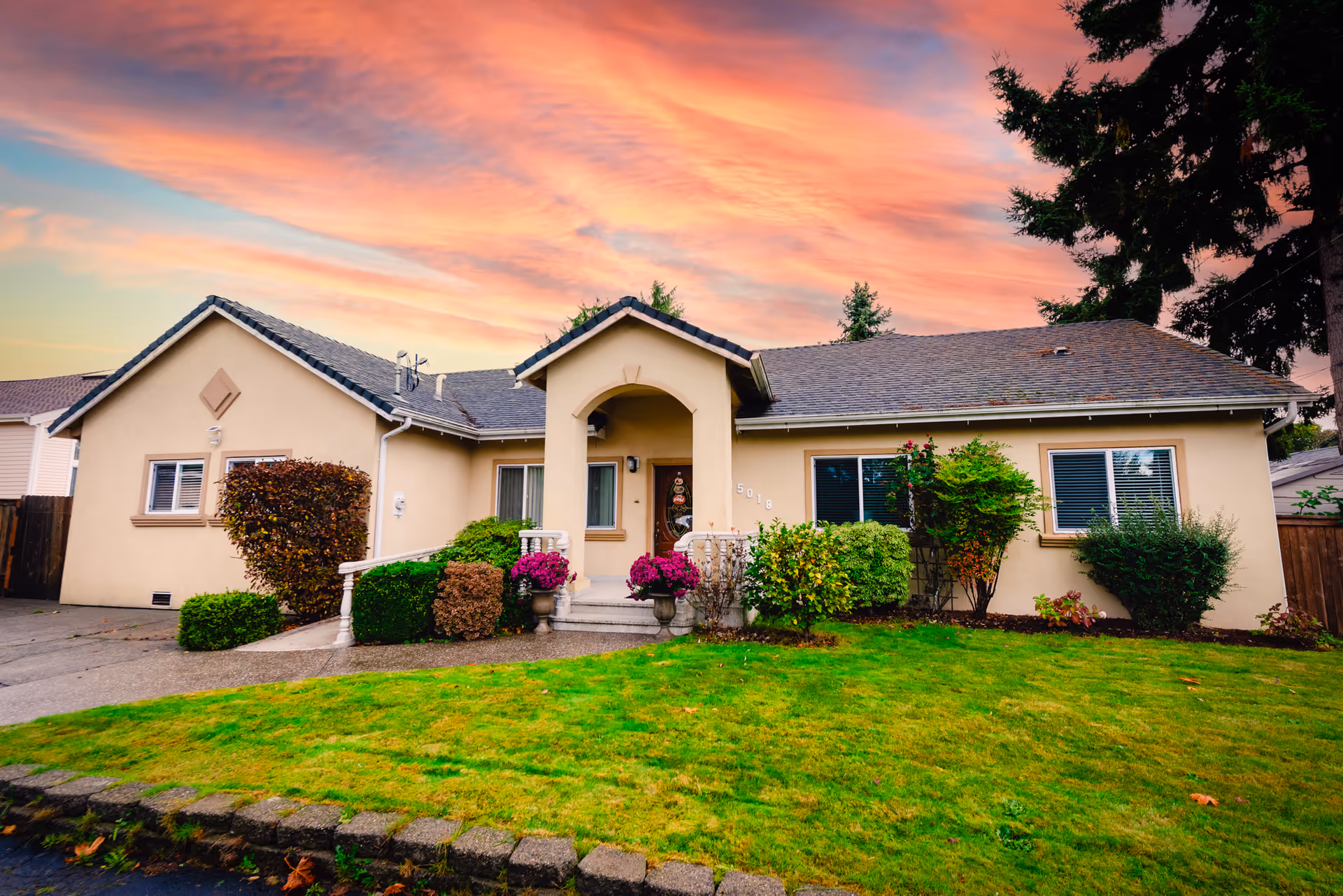 Front exterior of a single-story elderly home care residence with landscaped yard.