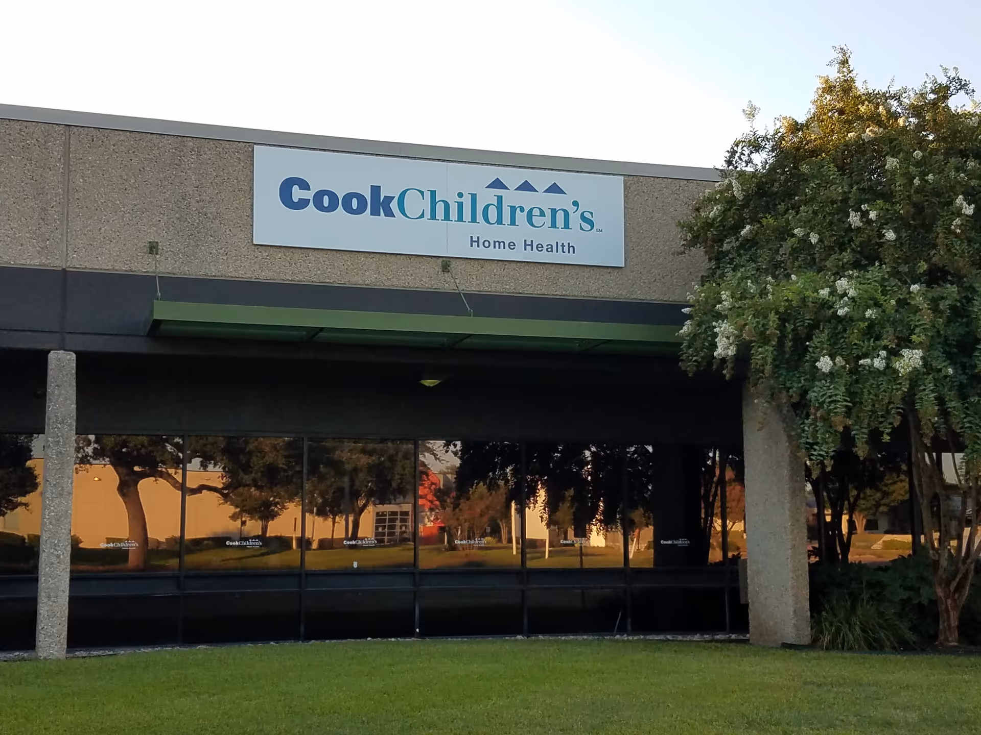 Exterior view of Cook Children's Home Health building with front sign and surrounding trees