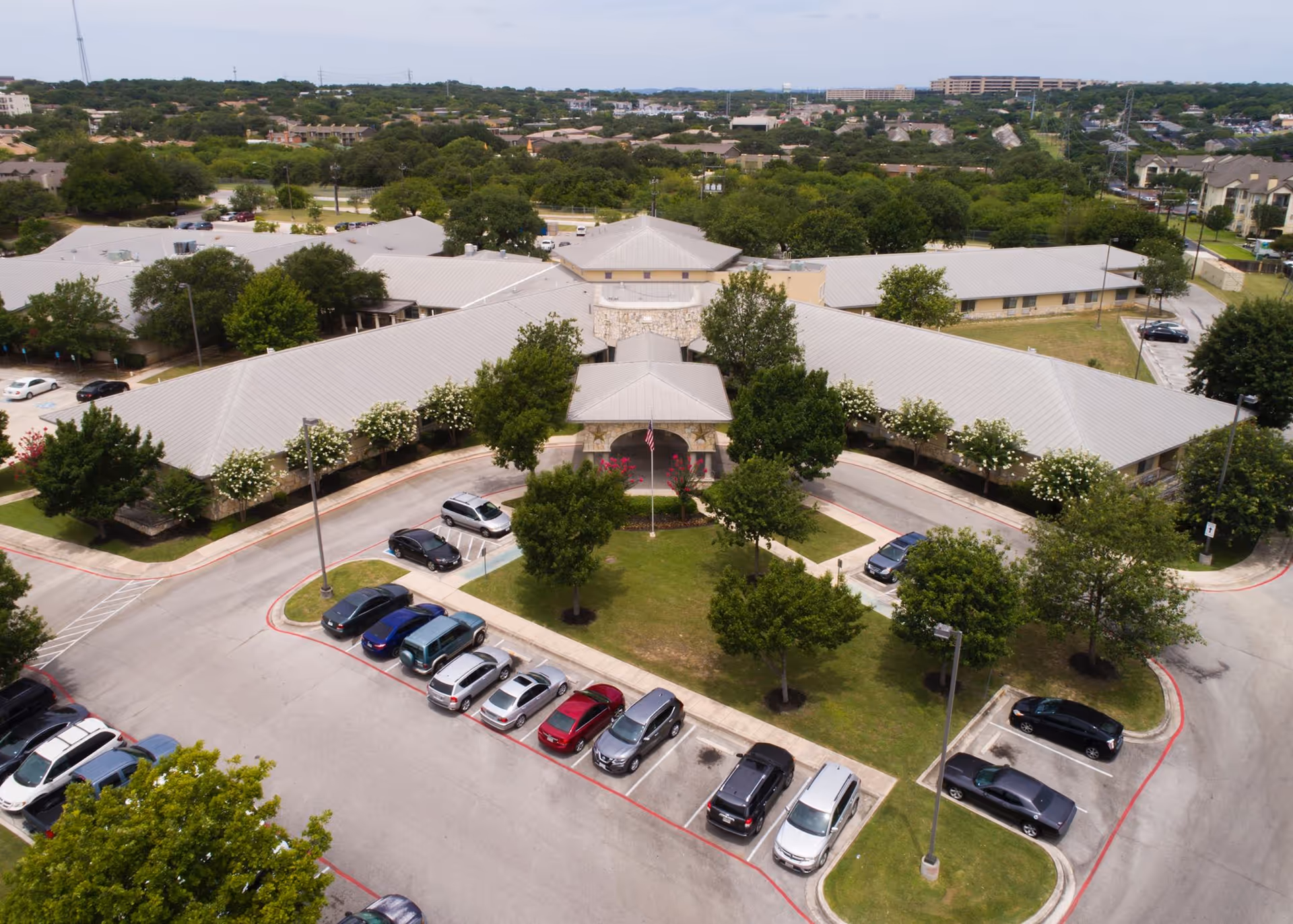 Aerial view of Regent Care at Medical Center facility with central entrance, surrounding parking, and trees.