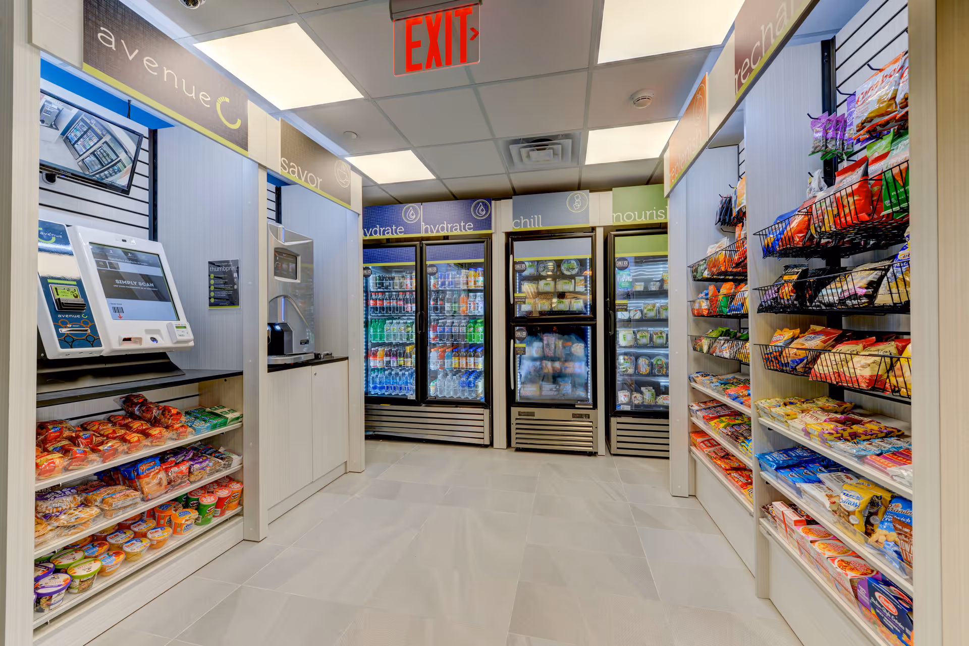 Small on-site convenience shop with refrigerated drink coolers and shelves of snacks and a checkout kiosk.