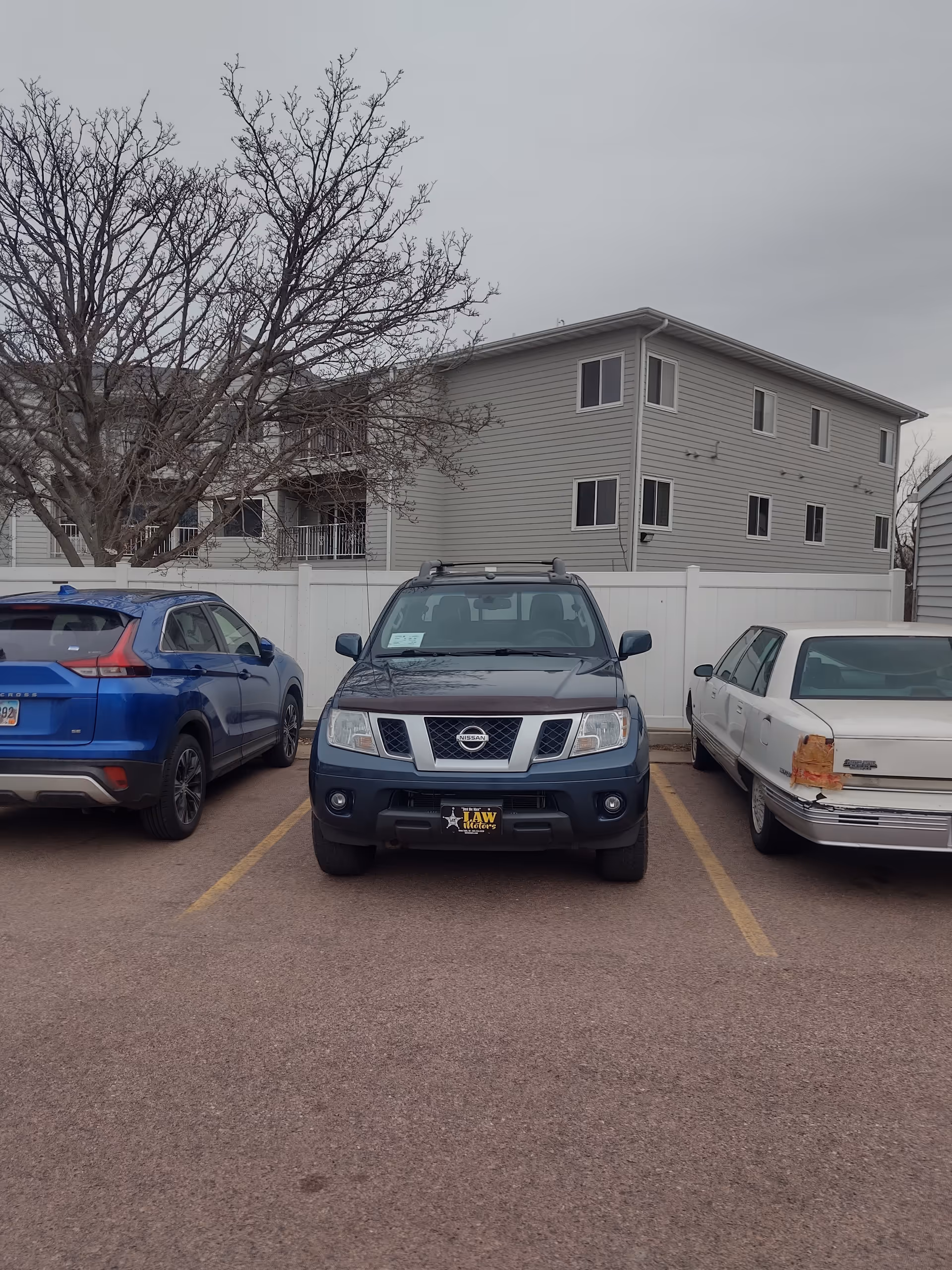 Exterior parking lot in front of Care Advocate facility with cars.