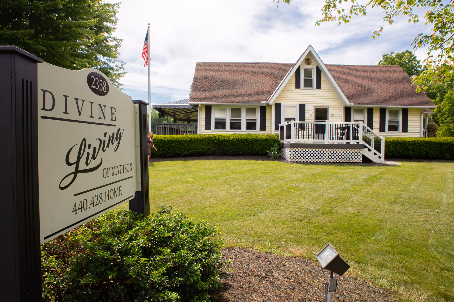 Front view of Divine Living of Madison house-style facility with sign and lawn.