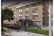 Exterior view of Throgs Neck Rehabilitation & Nursing Center entrance with brick facade.