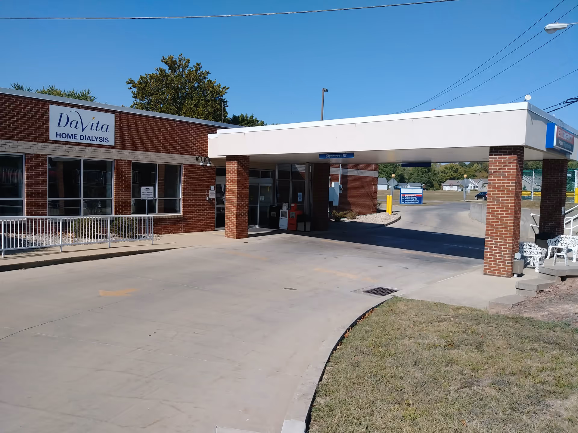 Exterior view of a brick facility with a DaVita Home Dialysis sign and drive-through.