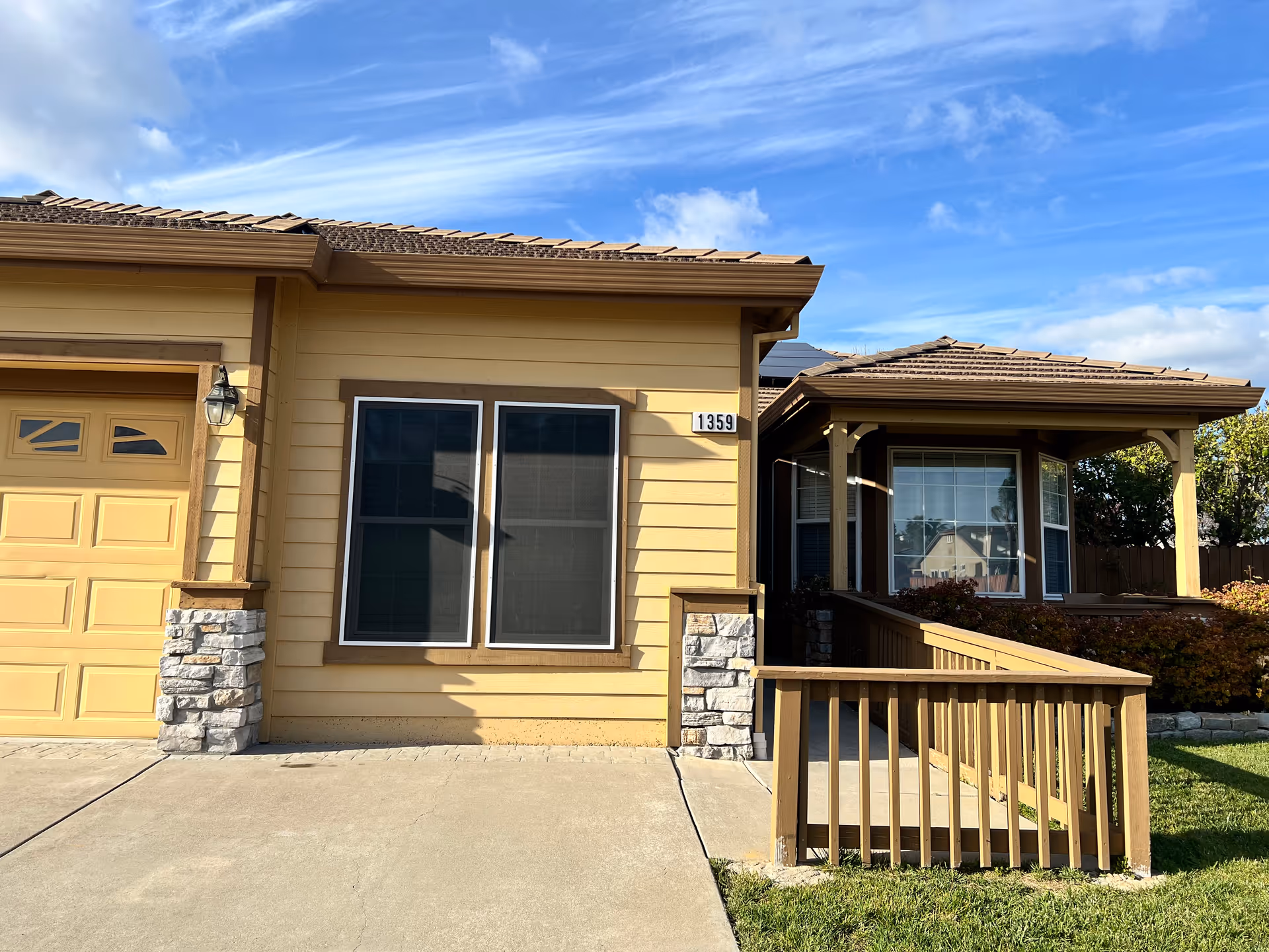 Front exterior of a tan, single-story senior care home with a porch.