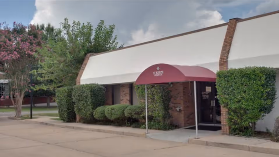Facade of a senior facility with a maroon canopy over the entrance.