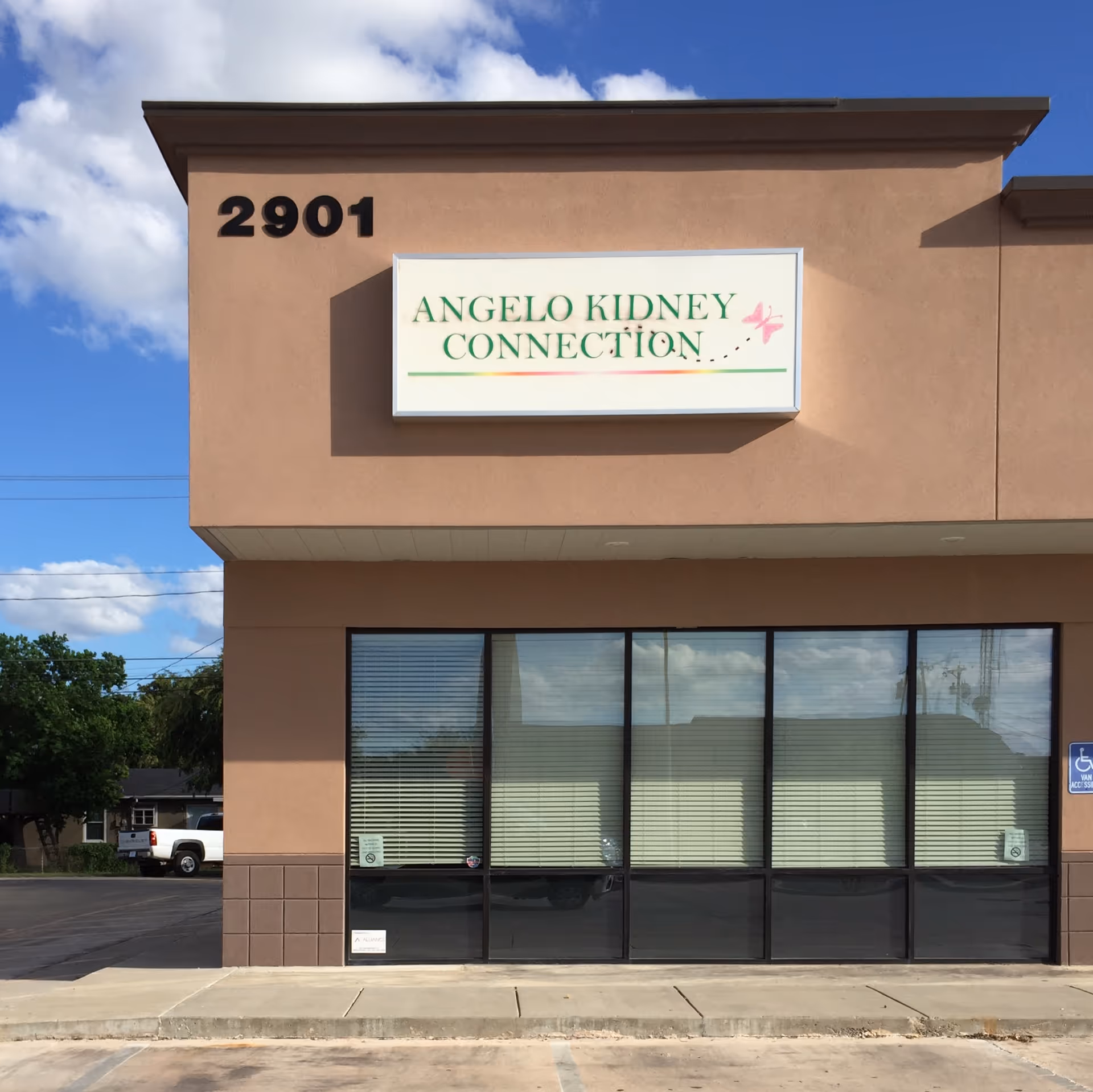 Tan stucco building with large storefront windows and a sign reading Angelo Kidney Connection at 2901