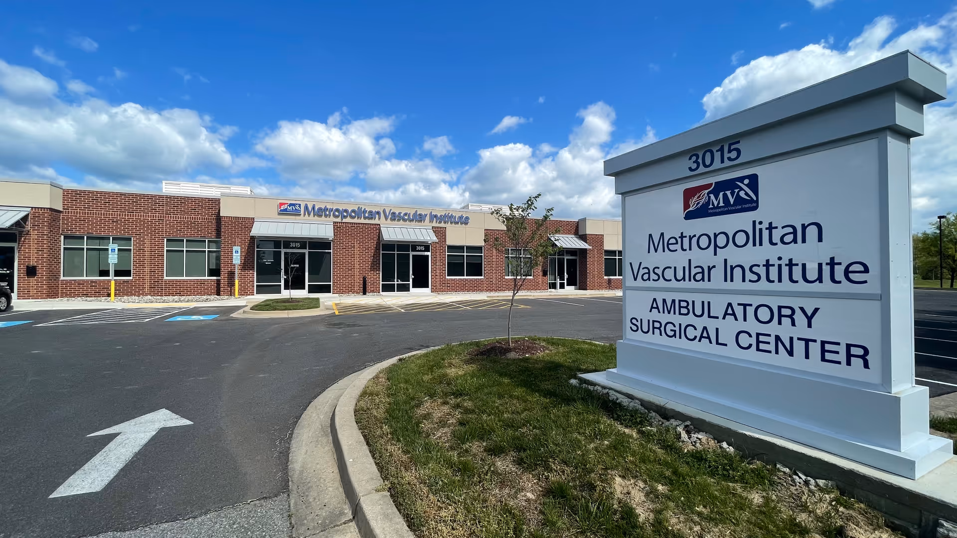Exterior view of Metropolitan Vascular Institute ambulatory surgical center with large sign and parking lot.