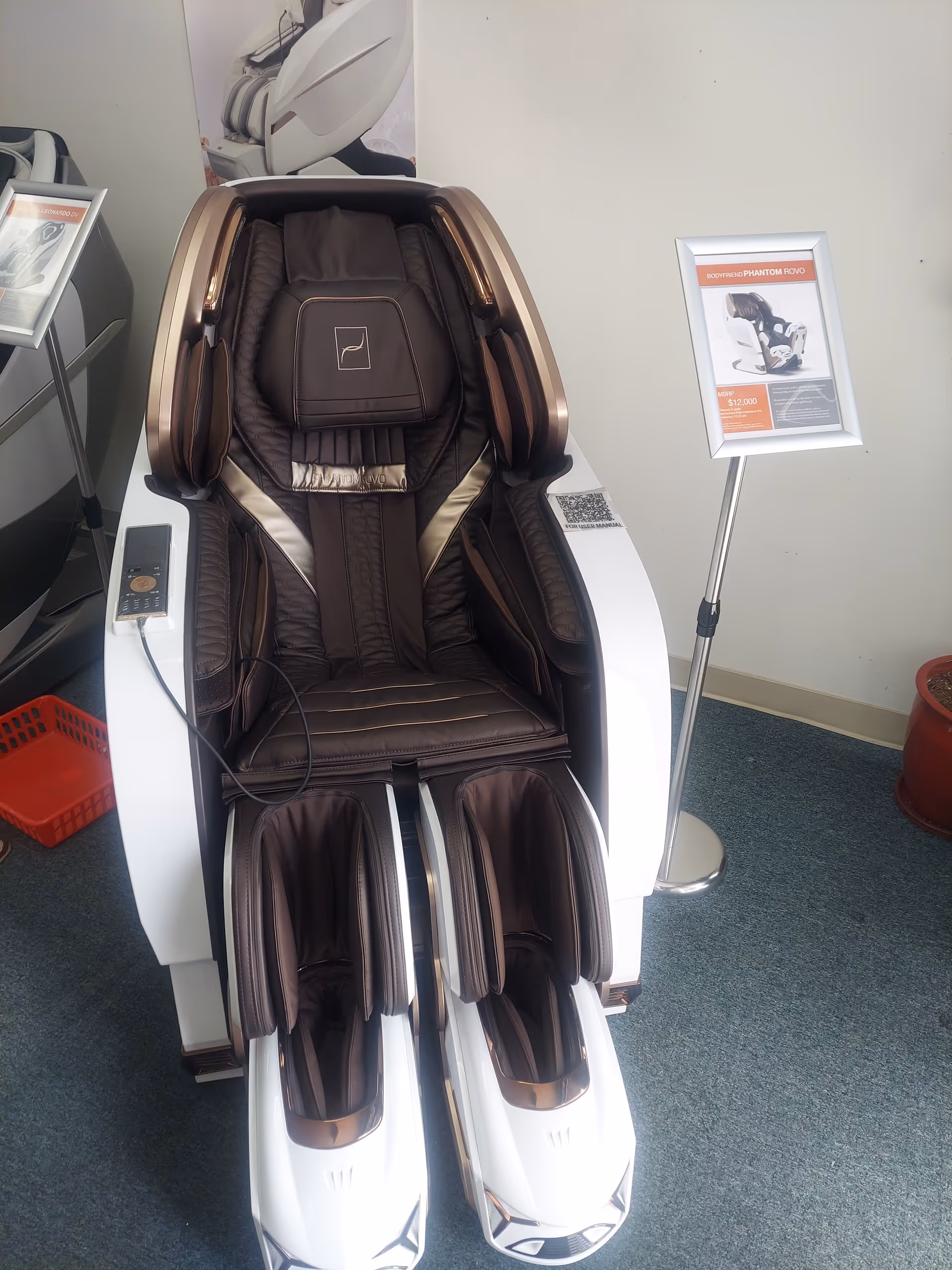 Brown massage chair on display in a showroom with brochure stand.