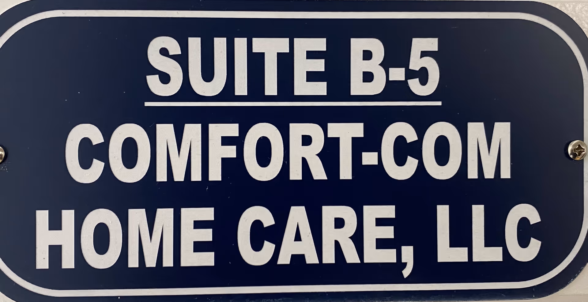 Blue sign reads 'SUITE B-5 COMFORT-COM HOME CARE, LLC'.