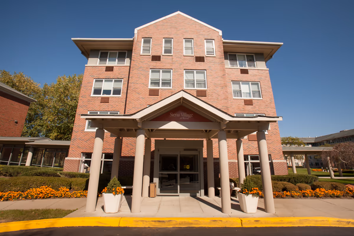 Brick Siena Village at Wayne exterior features a covered entrance with flower planters.