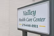 Exterior sign reading Valley Health Care Center mounted on building wall.
