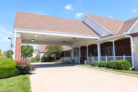 Exterior view of Vintage Park at Gardner with brick building, covered entrance, and landscaped driveway.