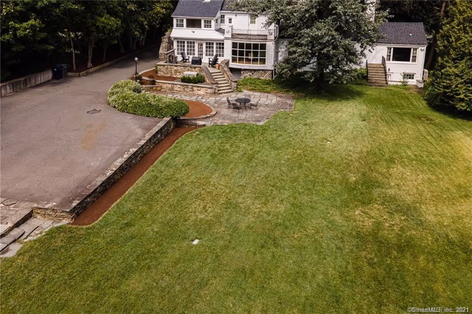 Aerial view of Old Glory Days senior living facility with stone patio and expansive lawn.