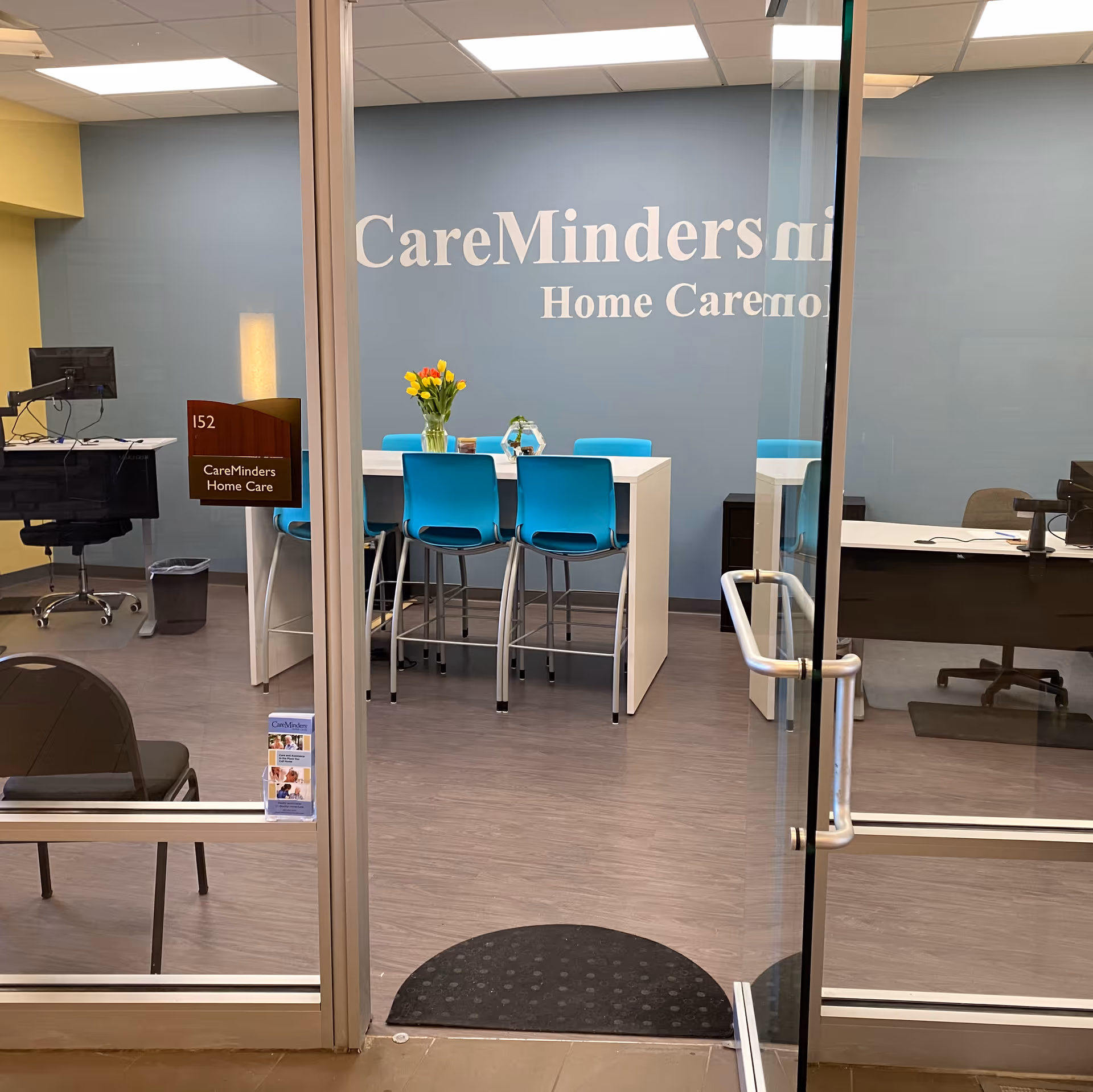 Reception area of CareMinders Home Care with blue chairs around a white table