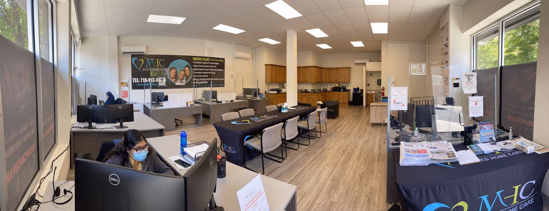 Bright, open reception and work area inside Marks Home Care facility with desks, computers, and signage.